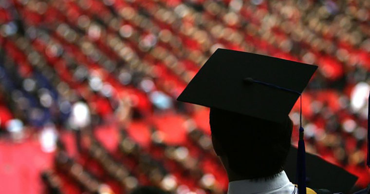 Student standing up at a graduation ceremony.