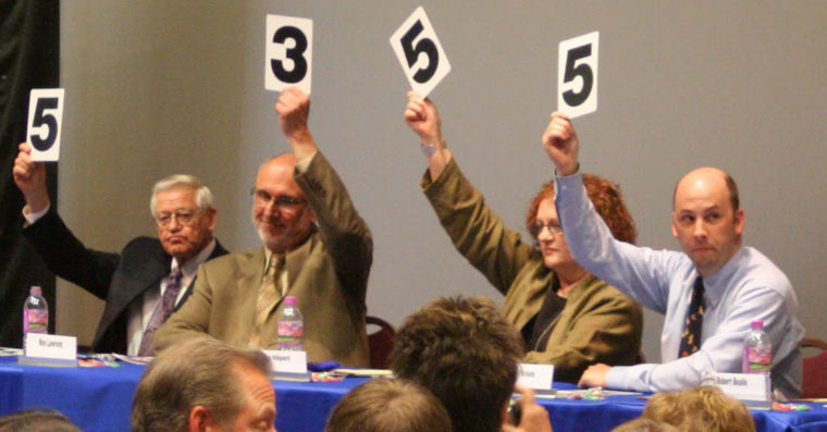 Judges scoring with numbers raised high. 