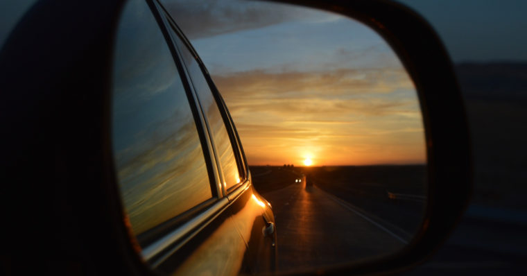 View of a sunset through a rear-view mirror.