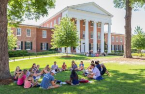 Photo of students on a law in front of a campus building at the University of Mississippi. 